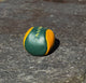 Green and orange footbag on a textured stone surface