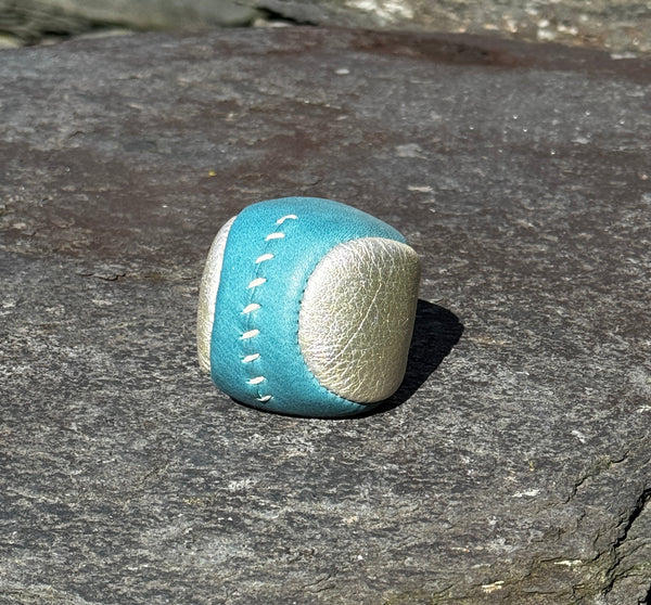 Blue and silver footbag on a rock wall